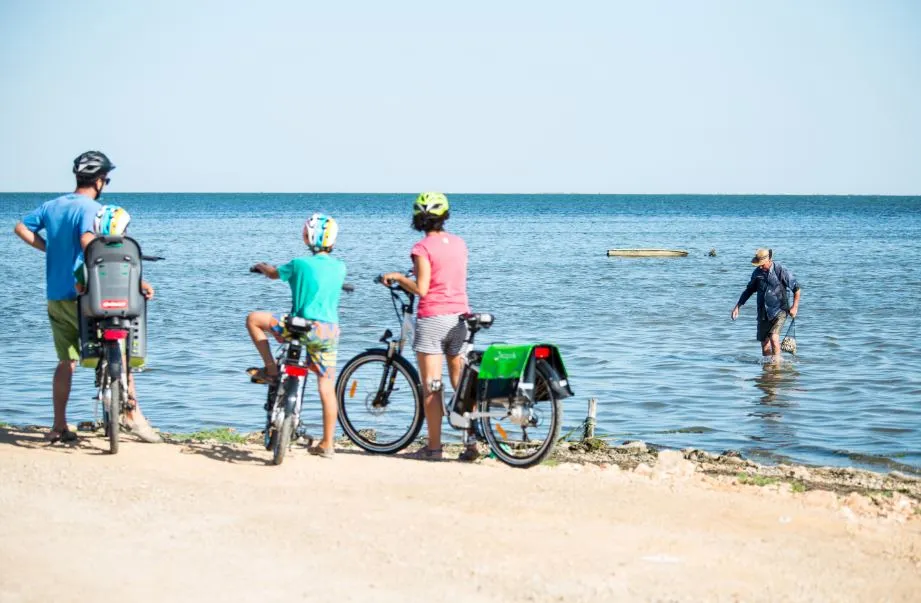 familia en bici frente a playa
